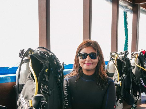 PADI AmbassaDiver Kritika Goel posing for a photo inside a boat.